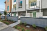 front exterior of gray and brown condo building with gray brick entry courtyard