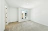 bedroom with tan carpet, white walls, and window