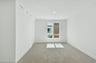 bedroom with tan carpet, white walls, and window