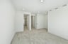 bedroom with white walls, tan carpet, and view of attached bathroom