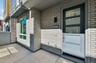 front entry courtyard to condo with gray brick and black front door