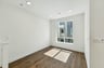 room with wood floors, white walls, recessed ceiling lights, and large window