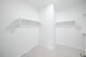 primary bedroom closet with carpet and white shelves