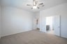 primary bedroom with carpet and ceiling fan