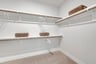 primary closet with wire shelves and carpet
