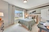 secondary bedroom with two windows and carpet