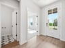 foyer with brown flooring, door and pendant lighting