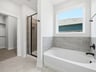 bathroom with walk in shower and tub