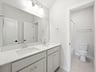 bathroom with dual sinks and soaking tub
