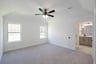 primary bedroom with carpet and ceiling fan