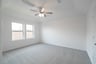 primary bedroom with carpet and windows