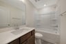 secondary bath with a shower and tub combo