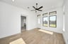 wood-like tile flooring and tall ceilings with fan