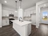 kitchen with quartz countertops, pendant lighting & white cabinets