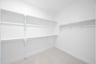 primary bedroom closet with carpet and white shelves