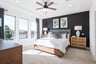 large primary bedroom with carpet and windows