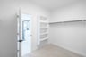 primary bedroom closet with carpet and white shelves