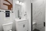 bathroom with walk-in shower and white cabinets