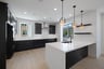 kitchen with black cabinets, white counters, light wood floors, and two windows