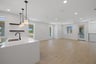 great room with light wood floors, white walls, multiple windows, and recessed ceiling lights