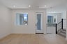 dining room with light wood floors, two large windows, and french door leading to balcony