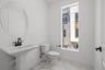 bathroom with window, round mirror above pedestal sink, and white & gray tile floor