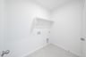 laundry room with tile floors and white shelf