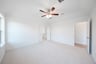primary bedroom with carpet and ceiling fan