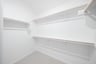 primary bedroom closet with carpet and white shelves