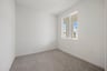 study with tan carpet, white walls, and window