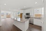 kitchen with white cabinets, granite counters, window, island, and wood floors