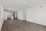 great room with wood floors, white walls, and view of adjacent kitchen