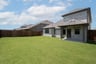 covered patio that opens up to large fenced backyard 