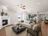 great room with brown flooring, fireplace and ceiling fan