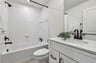 secondary bathroom with a shower and tub combo