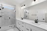primary bathroom with two sinks and an oversized shower