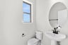 powder room with an oval mirror and a window
