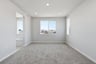 bedroom with tan carpet, light gray walls, two windows, and view of attached bathroom