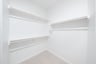 primary bedroom closet with carpet and white shelves