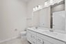 primary bathroom with white cabinets and mirror