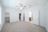 primary bedroom with carpet and ceiling fan