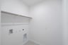 laundry room with tile floors and white shelf