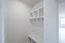 mudroom with wood floors and white shelves with bench