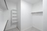 primary bedroom closet with carpet and white shelves