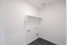 laundry room with tile floors and white shelf