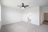 primary bedroom with carpet and ceiling fan