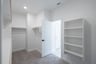  primary bedroom closet with carpet and white shelves