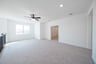 open loft with carpet and ceiling fan