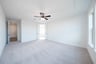 primary bedroom with carpet and ceiling fan