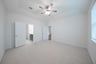 primary bedroom with carpet and ceiling fan